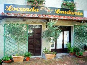a restaurant with potted plants in front of a building at Locanda Laudomia in Manciano