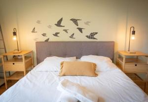 um quarto com uma cama com pássaros na parede em Le jardin de Christine em Saint-Martin-dʼHères