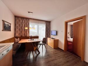 a small room with a table and a bedroom at Appart Kofler in Gerlos