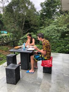 mężczyzna i kobieta siedzący przy stole piknikowym w obiekcie Sun Villa 
