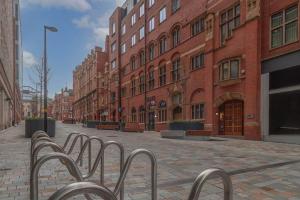 a street with a row of benches in front of buildings at Rooms in Birmingham City Centre in Birmingham