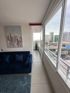 a living room with a couch and a large window at Departamento 1D1B Matiz Central in Iquique