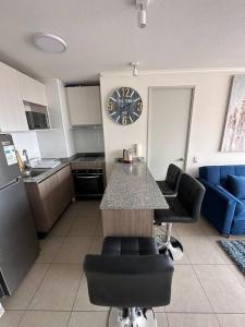 a kitchen with a counter and a clock on the wall at Departamento 1D1B Matiz Central in Iquique