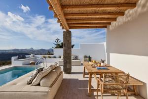 a patio with a couch and a table and a pool at Villa Manikas Milos in Adamas