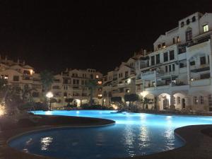 a large swimming pool at night with white buildings at Roquemar dreams 523 in Roquetas de Mar