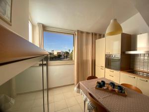 une cuisine avec une table et une fenêtre dans l'établissement House Blue Roses Apartment Step Up in Puglia for your Niksen, à Bari