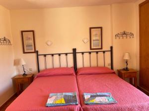 a bedroom with a red bed with two books on it at Roquemar dreams 435 in Roquetas de Mar