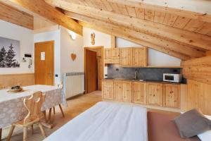 una cocina con armarios de madera y una mesa en una habitación en Chalet Primula 13 en Santa Caterina Valfurva