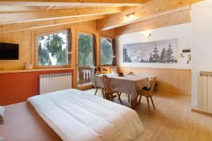 a bedroom with a bed and a table in a room at Chalet Primula 13 in Santa Caterina Valfurva