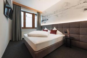 um quarto de hotel com uma cama e uma televisão em Leni Mountain Appartements em Sölden