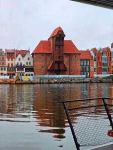 a view of a body of water with a building at Domki na wodzie - Apartament Korweta Gdańsk - Stare Miasto flota Possession pl in Gdańsk