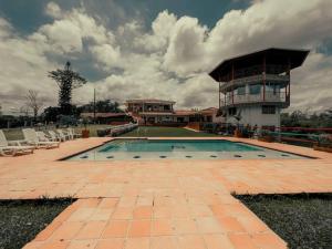 佩雷拉的住宿－finca turística DanuBio Alojamiento Rural Pereira Risaralda，一座大型游泳池,其建筑背景为: