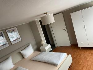 a bedroom with a white bed and a white cabinet at Moderne Dachgeschosswohnung mit 2 Schlafzimmern in Würzburg