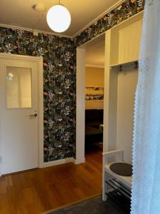 Zimmer mit einem Flur und einer mit Blumen bedeckten Wand in der Unterkunft The Guest House. in Gammelstaden