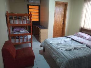 niewielka sypialnia z łóżkiem, krzesłem i krzesłem w obiekcie La posada w mieście São Gabriel