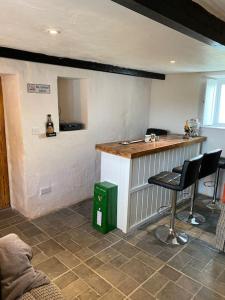 a kitchen with a counter and chairs in a room at An Teach Uachtarach in Omagh +19 photos