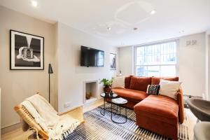 a living room with a couch and a tv at The Myddelton Square - Cosy 1BDR Flat in London