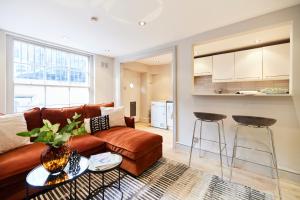 a living room with a couch and two bar stools at The Myddelton Square - Cosy 1BDR Flat in London