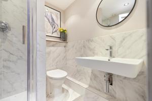 a bathroom with a sink and a toilet and a mirror at The Myddelton Square - Cosy 1BDR Flat in London