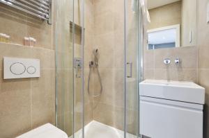 a bathroom with a shower and a toilet and a sink at Golders Green Serviced Apartments by Concept Apartments in London