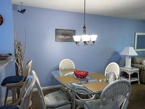 comedor con mesa y sillas blancas en Colony III 203 Condo, en Myrtle Beach