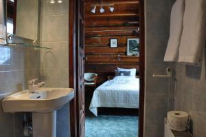 a bathroom with a sink and a bedroom with a bed at Willa Marma B&B in Zakopane
