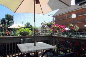 a table with an umbrella on a balcony at Arbors at Island Landing Hotel & Suites in Pigeon Forge