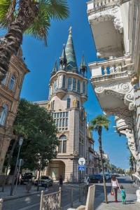 a tall building with a tower on a city street at Batumi Center 3 Rooms City Side in Batumi