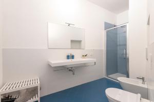 een witte badkamer met een wastafel en een spiegel bij Tree Apartment BG in Bergamo +17 foto's