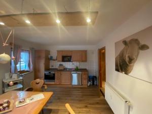 a kitchen with a painting of a cow on the wall at Weber´s Fewo in Graswang