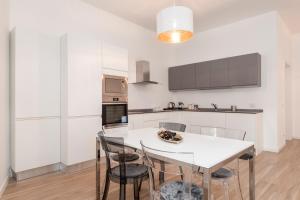 een witte keuken met een witte tafel en stoelen bij Tree Apartment BG in Bergamo