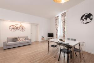 een woonkamer met een tafel en een bank bij Tree Apartment BG in Bergamo