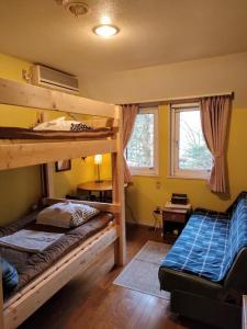 a bedroom with two bunk beds and a desk at Bellscabin Guesthouse in Karuizawa