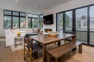 sala de estar con mesa, sillas y chimenea en 8th Street Luxury Townhome Unit 101, en Ketchum