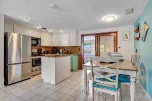 a kitchen with a table and a stainless steel refrigerator at Getaway on Gladiolus in Anna Maria