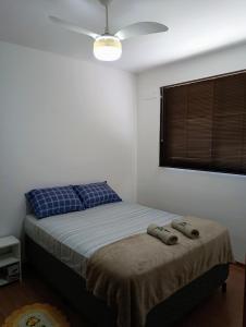a bedroom with a bed and a ceiling fan at Apartamento aconchegante Jd América in Maringá