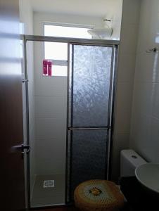 a shower with a glass door in a bathroom at Apartamento aconchegante Jd América in Maringá