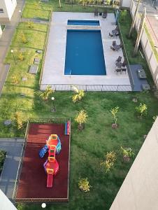 una vista aérea de una piscina y un coche de juguete en un césped en Apartamento aconchegante Jd América, en Maringá