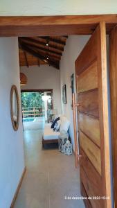 a bedroom with a bed and a wooden door at Casa Trancoso Refúgio in Trancoso