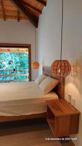a bedroom with a bed and a window and two lamps at Casa Trancoso Refúgio in Trancoso