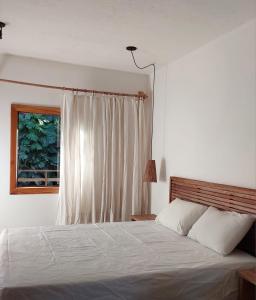 sypialnia z białym łóżkiem i oknem w obiekcie Casa Trancoso Refúgio w mieście Trancoso