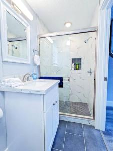 a white bathroom with a shower and a sink at Elegant 1 Bed Montrose - Venice @ Italian Plaza in Houston