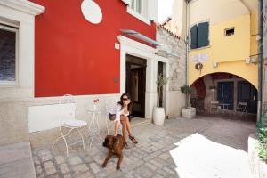 a woman and her dog sitting outside a building at Apartments Villa Bianca in Rovinj