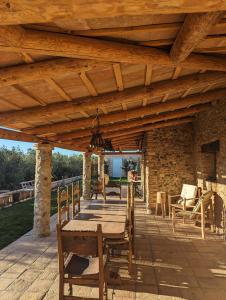 eine Holzterrasse mit einem Tisch und Stühlen darauf in der Unterkunft Casa Hostalets - Renovated casa in the middle of the olive trees near the beach in Riudoms
