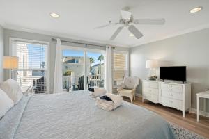 a white bedroom with a bed and a television at 21 Turtle Bay Carolina Tides in Folly Beach
