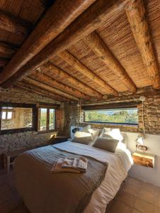 ein Schlafzimmer mit einem großen Bett in einem Zimmer mit Holzdecken in der Unterkunft Casa Hostalets - Renovated casa in the middle of the olive trees near the beach in Riudoms