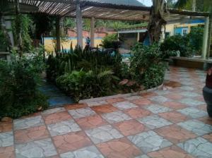 a courtyard with a stone floor and plants at Suites Baleia Verde in São Sebastião