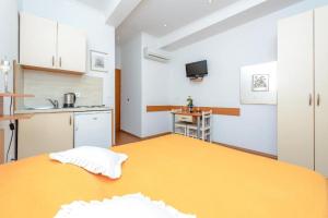 a bedroom with a large bed and a kitchen at Studio Apartments Stradun in Dubrovnik