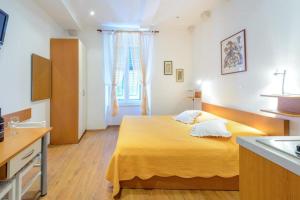 een slaapkamer met een bed en een keuken met een wastafel bij Studio Apartments Stradun in Dubrovnik