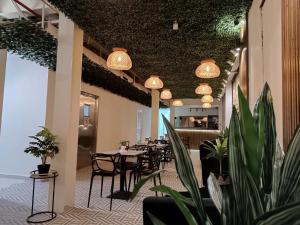 um restaurante com mesas e cadeiras e vasos de plantas em HOTEL BALUARTE BOUTIQUE PANAMA na Cidade do Panamá
